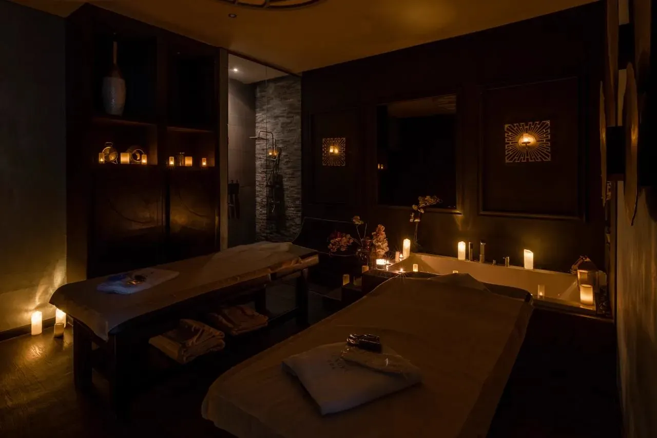 Candle-lit treatment room with two massage tables