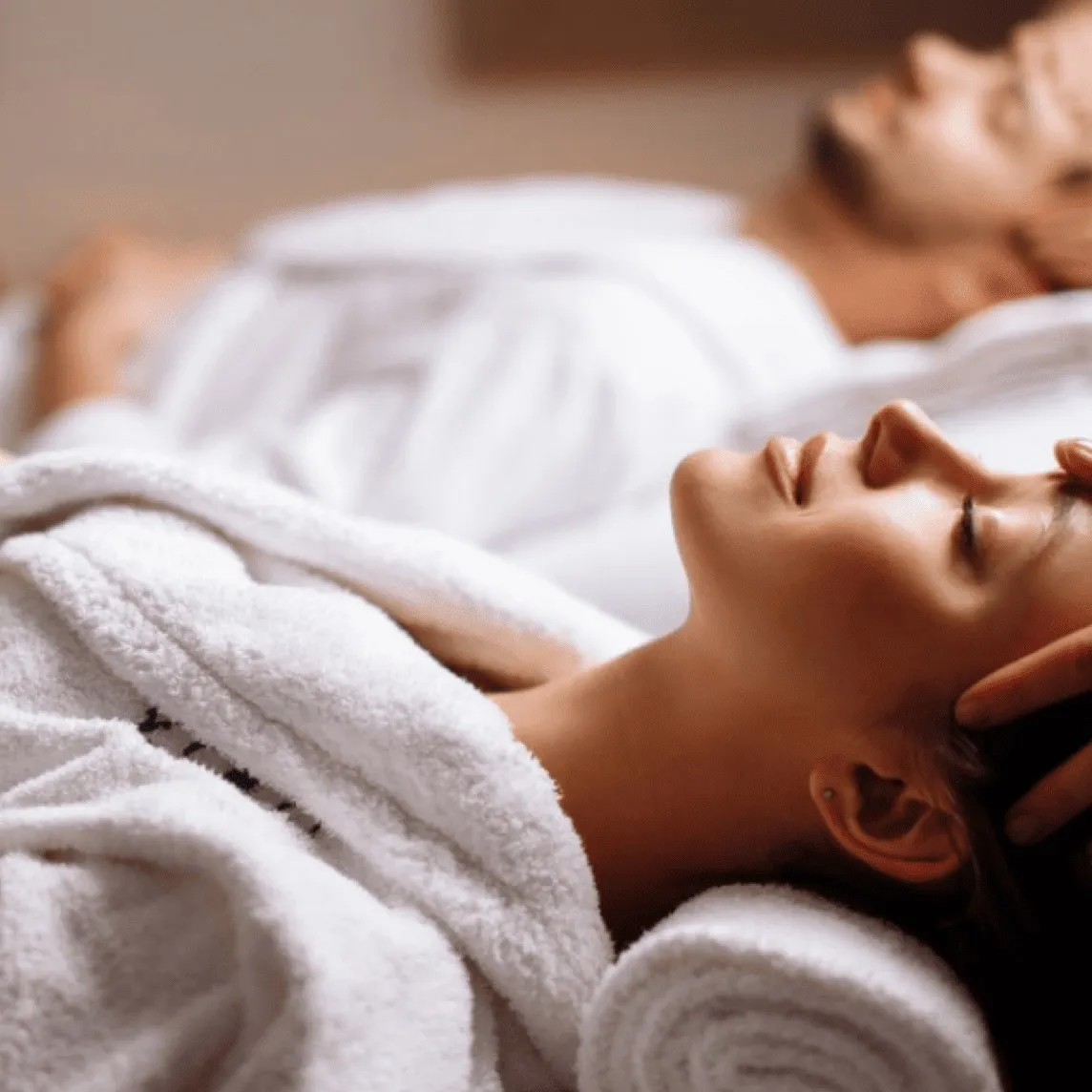 Two guests in white robes relaxing side by side during Indulgences for Two